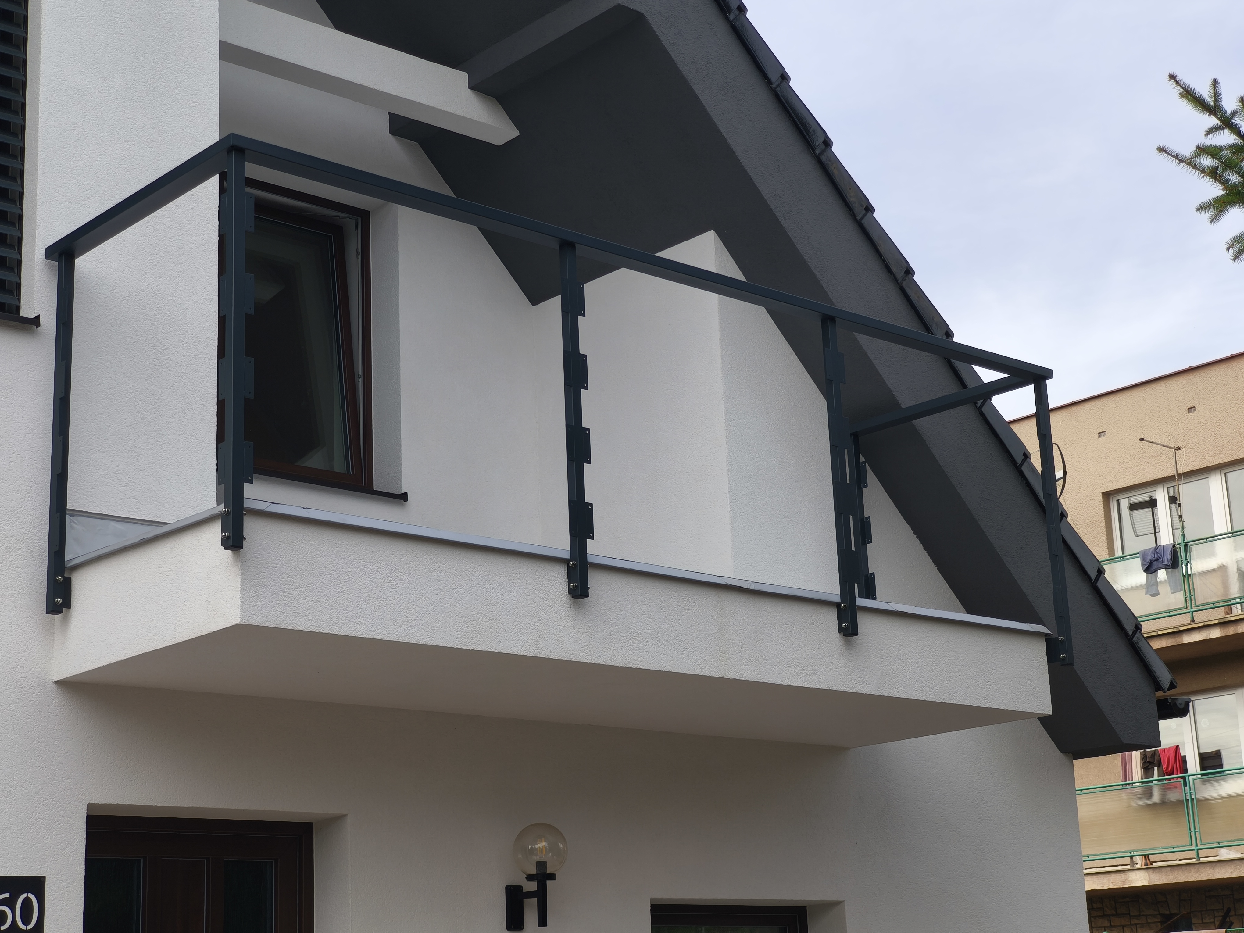 Antracitová konstrukce zábradlí na druhém balkónu domu v Kvíčku, připravená pro následnou montáž výplně.