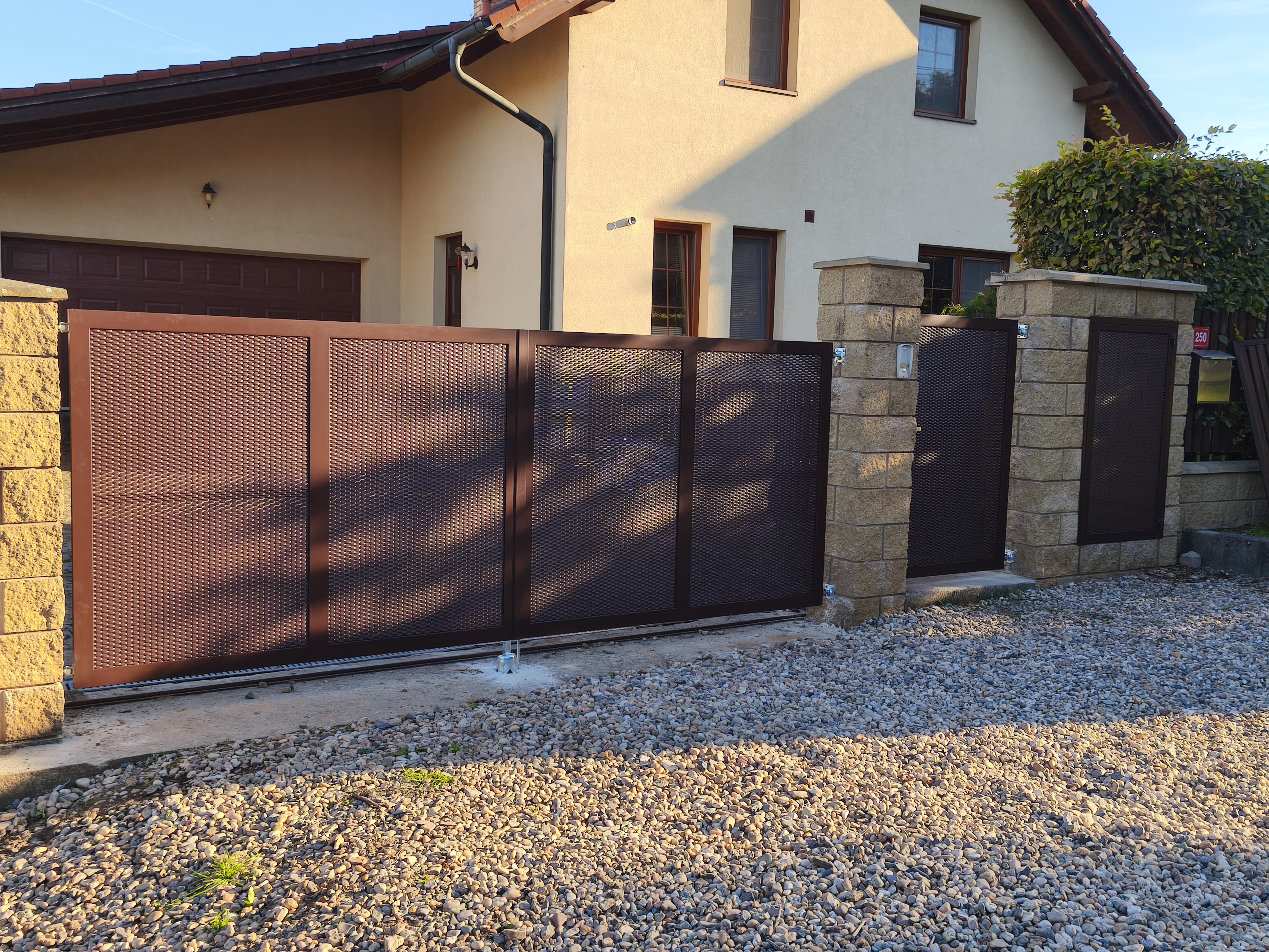 Celkový vnější pohled na novou hnědou bránu, vstupní branku a dvířka pro popelnici s tahokovem.