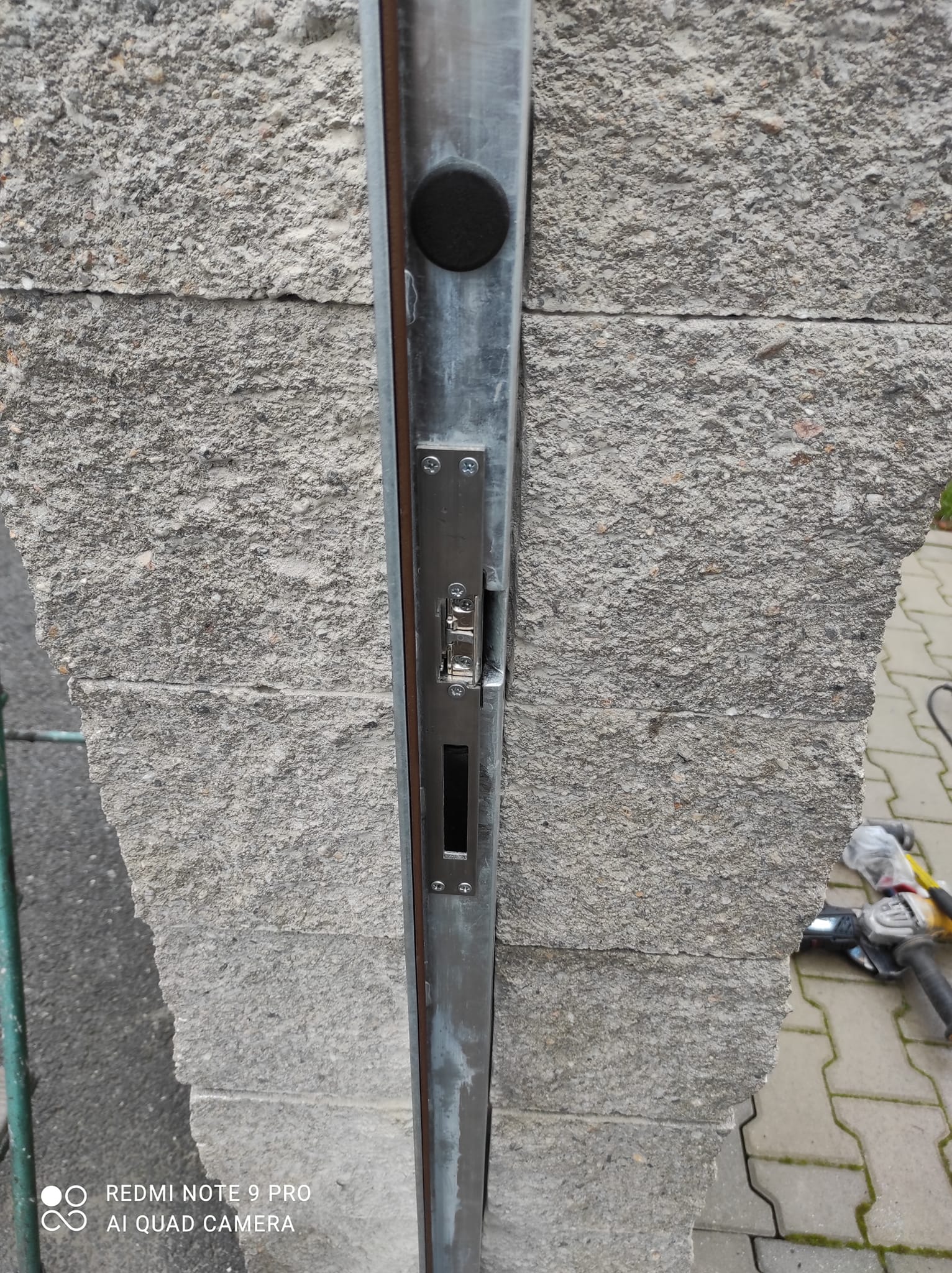 Detail zavíracího protikusu v kovovém profilu u sloupku vstupní branky.