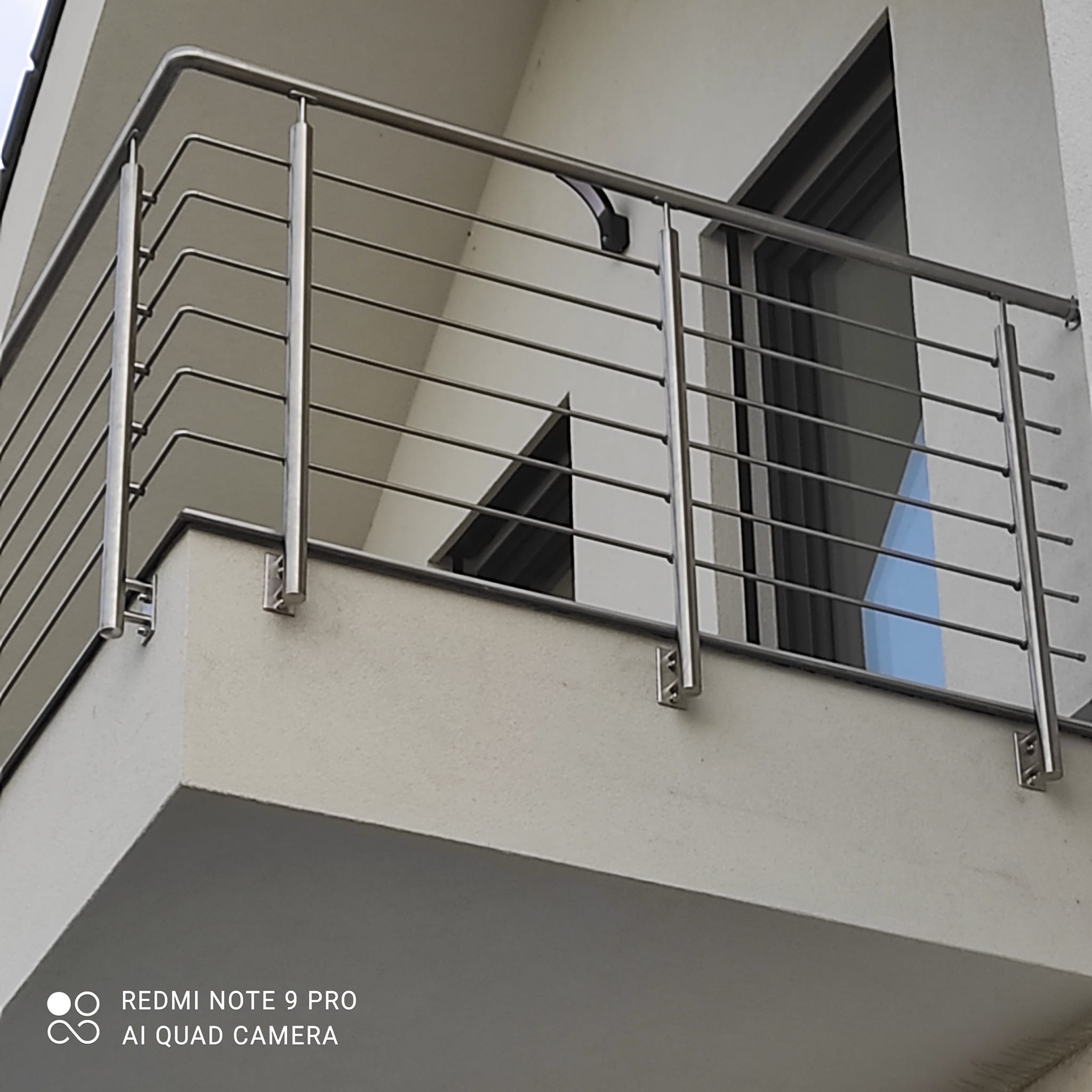 Bližší vnější pohled na sloupky nerezového zábradlí kotvené do čela balkónu v Rané.