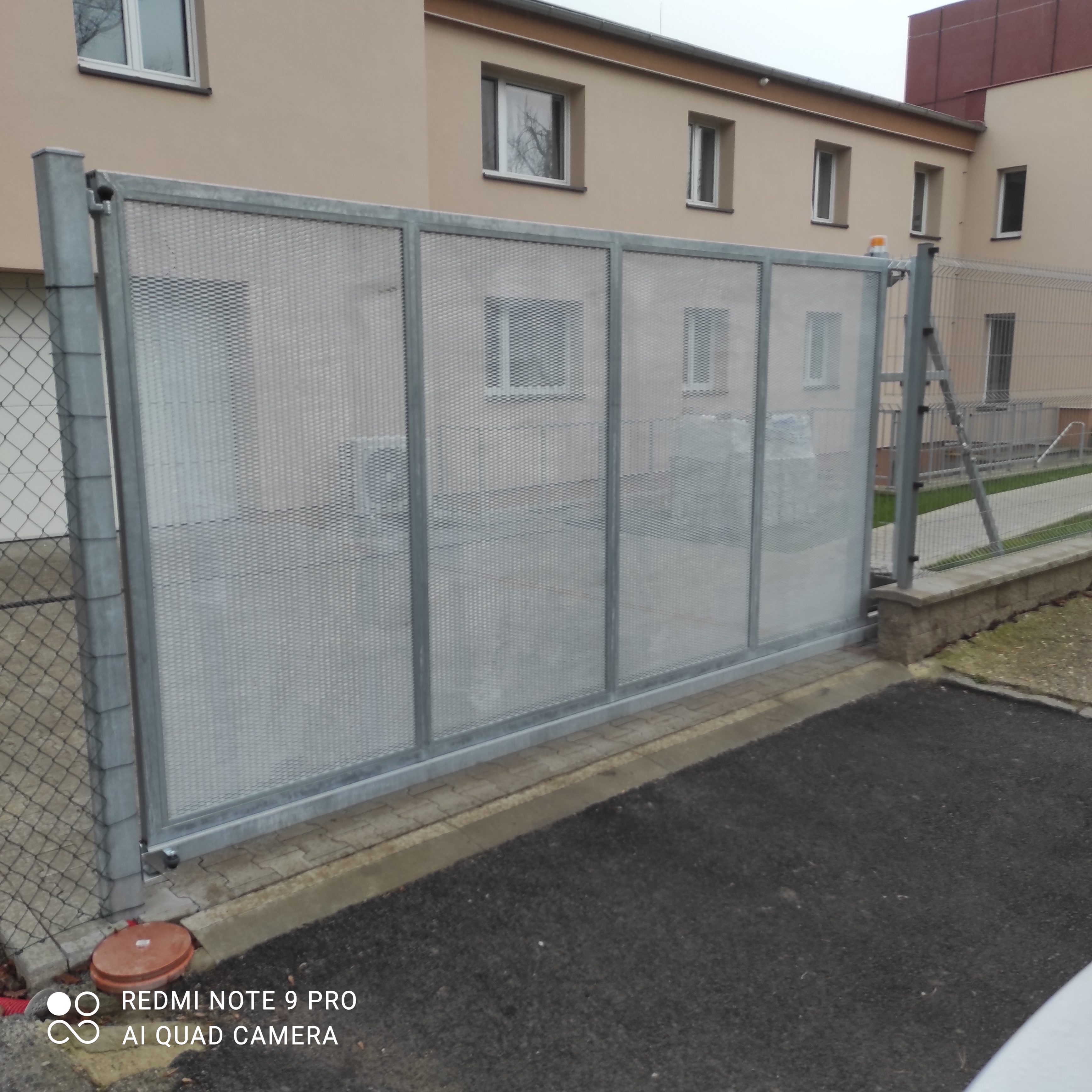 Celkový pohled zvenku na pozinkovanou samonosnou bránu s tahokovovou výplní.